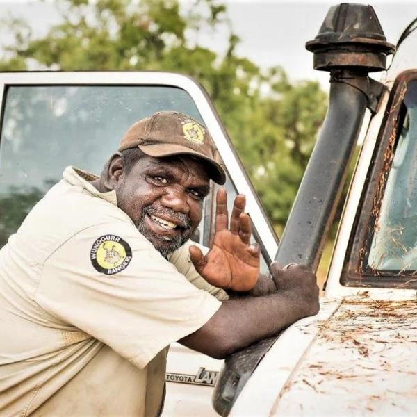 Indigenous man standing next to a Ute