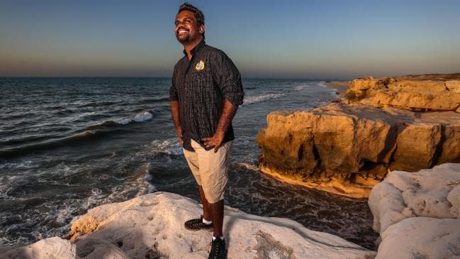 Man standing on rock by ocean