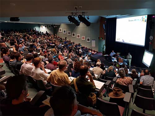 Speaker presenting to people in a theatre room